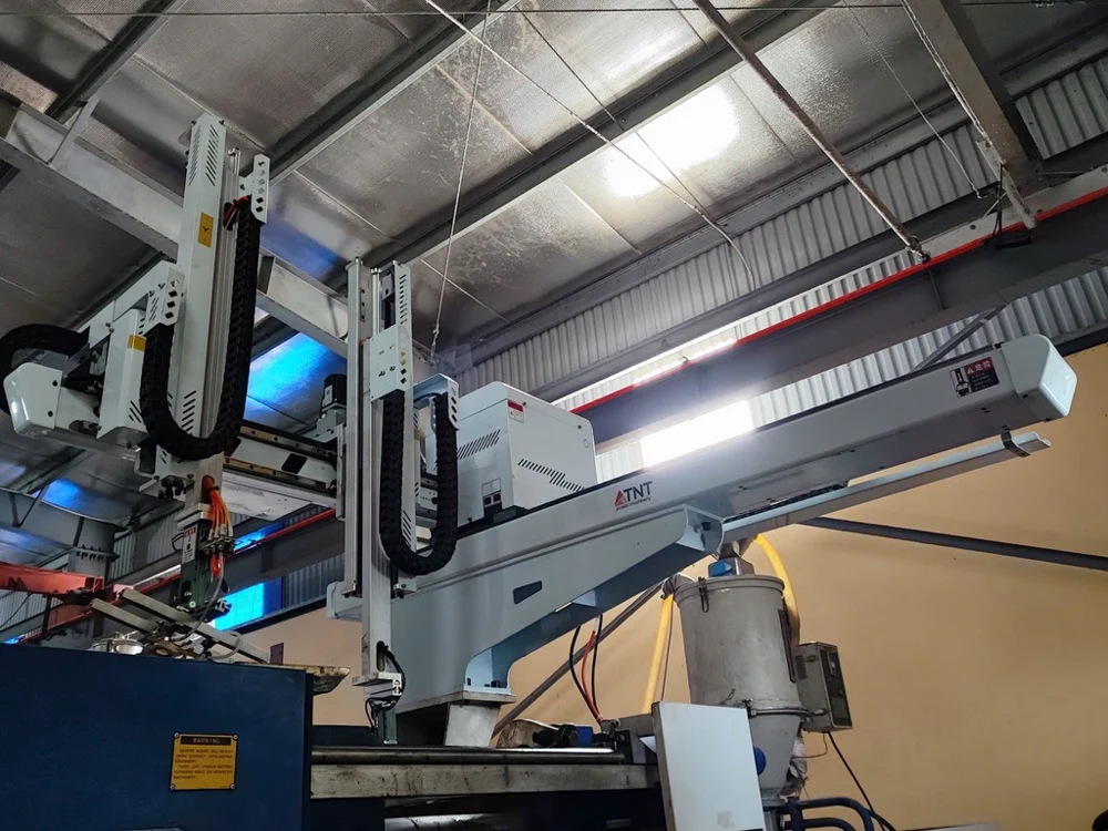 Robot TNT nhìn từ dưới lên, gắn phía trên máy ép trong xưởng